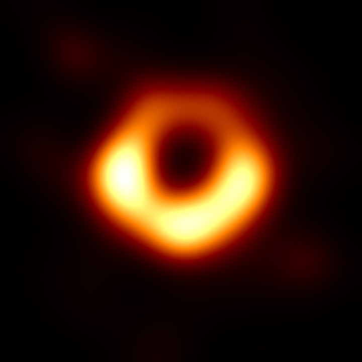 The real black hole M87*: a glowing orange ring around a dark centre.