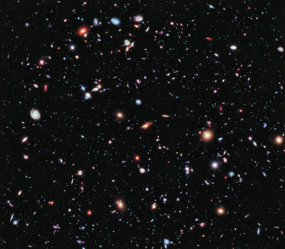 The Hubble eXtreme Deep Field: thousands of colourful galaxies of all shapes scattered across black space.